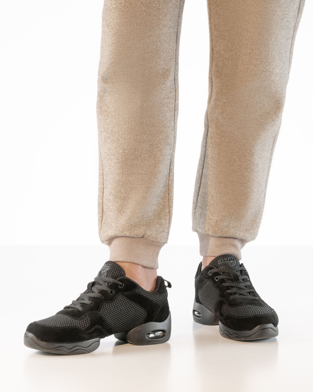 Baskets de danse noires au design chunky avec semelle fendue, signées Werner Kern, portées avec un pantalon beige