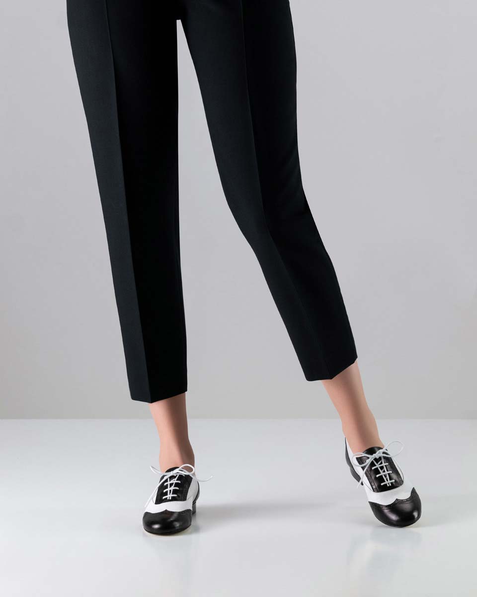 Chaussures de danse pour dames Swing en noir et blanc en combinaison avec un pantalon noir