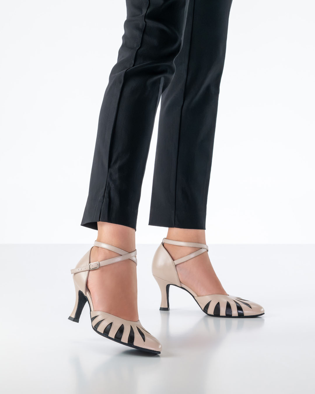 Un mannequin vêtu d'un pantalon noir moulant porte des chaussures de danse fermées de couleur beige, le modèle « Donatella » de Werner Kern.