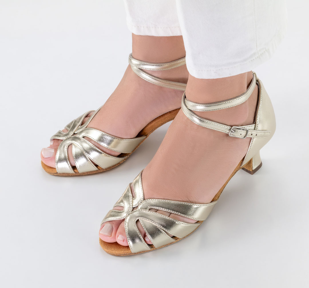 Sandales de danse ouvertes « Thea » en cuir nappa doré, avec un talon évasé de 5 cm, associées à un jean blanc de la marque Werner Kern