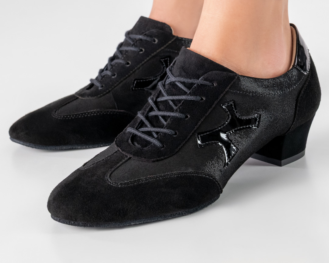 Gros plan sur la chaussure de danse d'entraînement Bruni en noir brillant avec des détails de baskets en cuir velours.