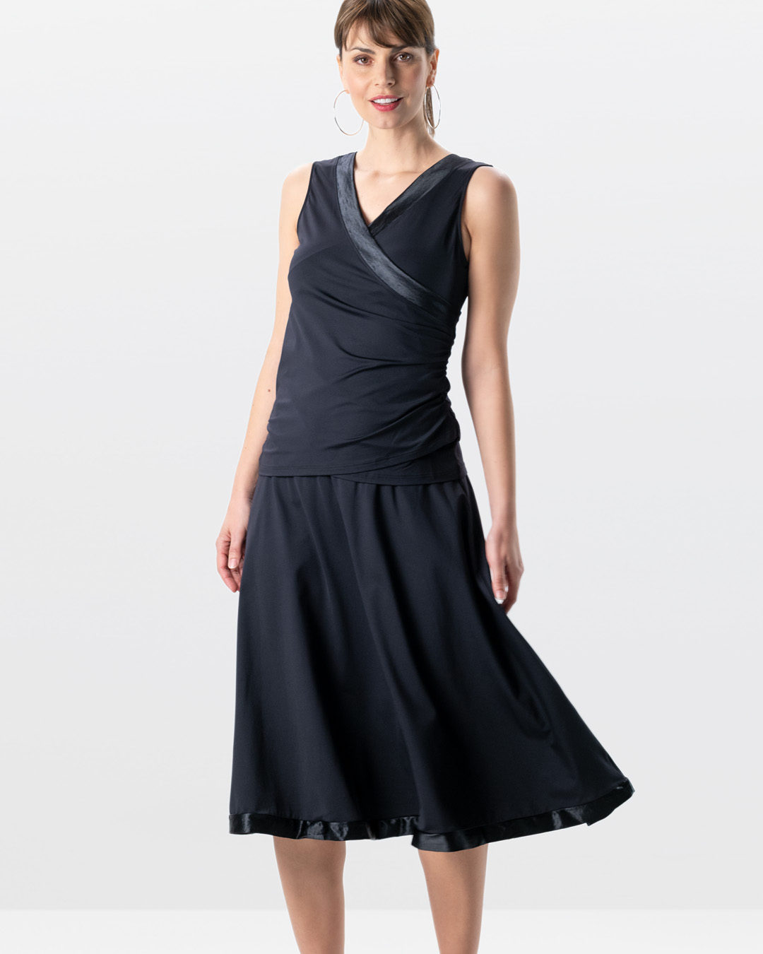 Le mannequin en studio porte le haut de danse Sira associé à la jupe de danse longue Sari noire.