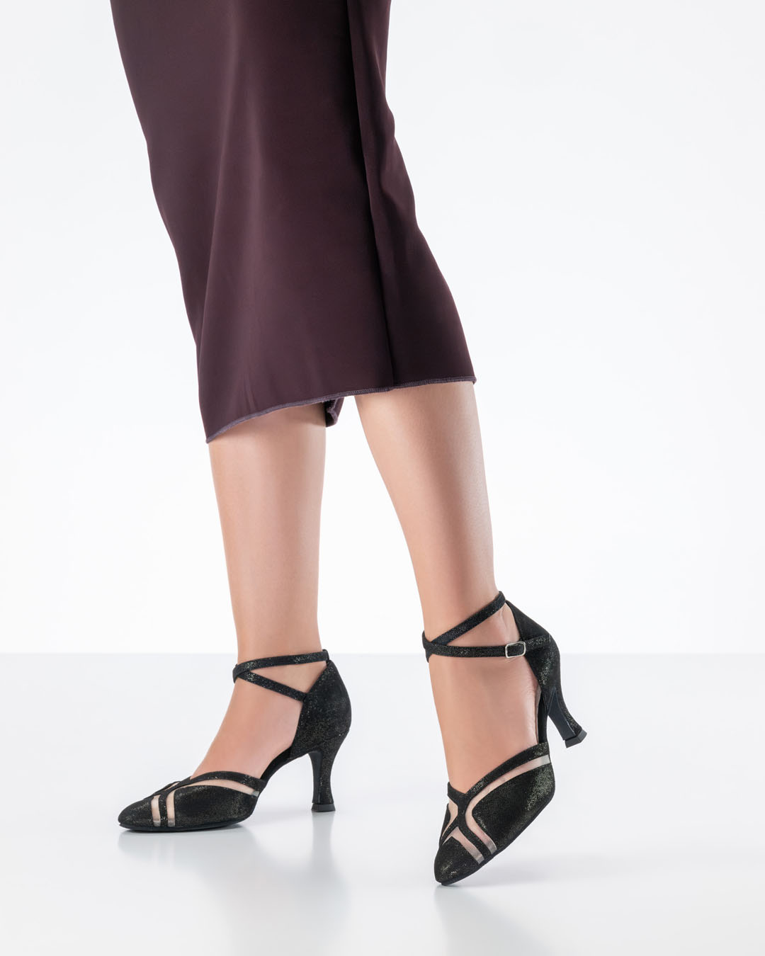 Mannequin vêtue d'une robe moulante rouge foncé et de chaussures de danse noires brillantes signées Werner Kern, à talons de 6,5 cm
